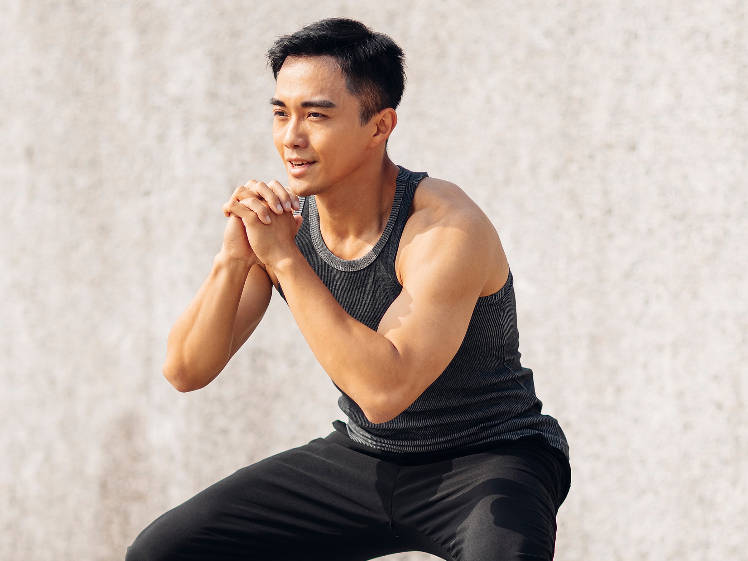 Man performing a squat exercise outdoors.